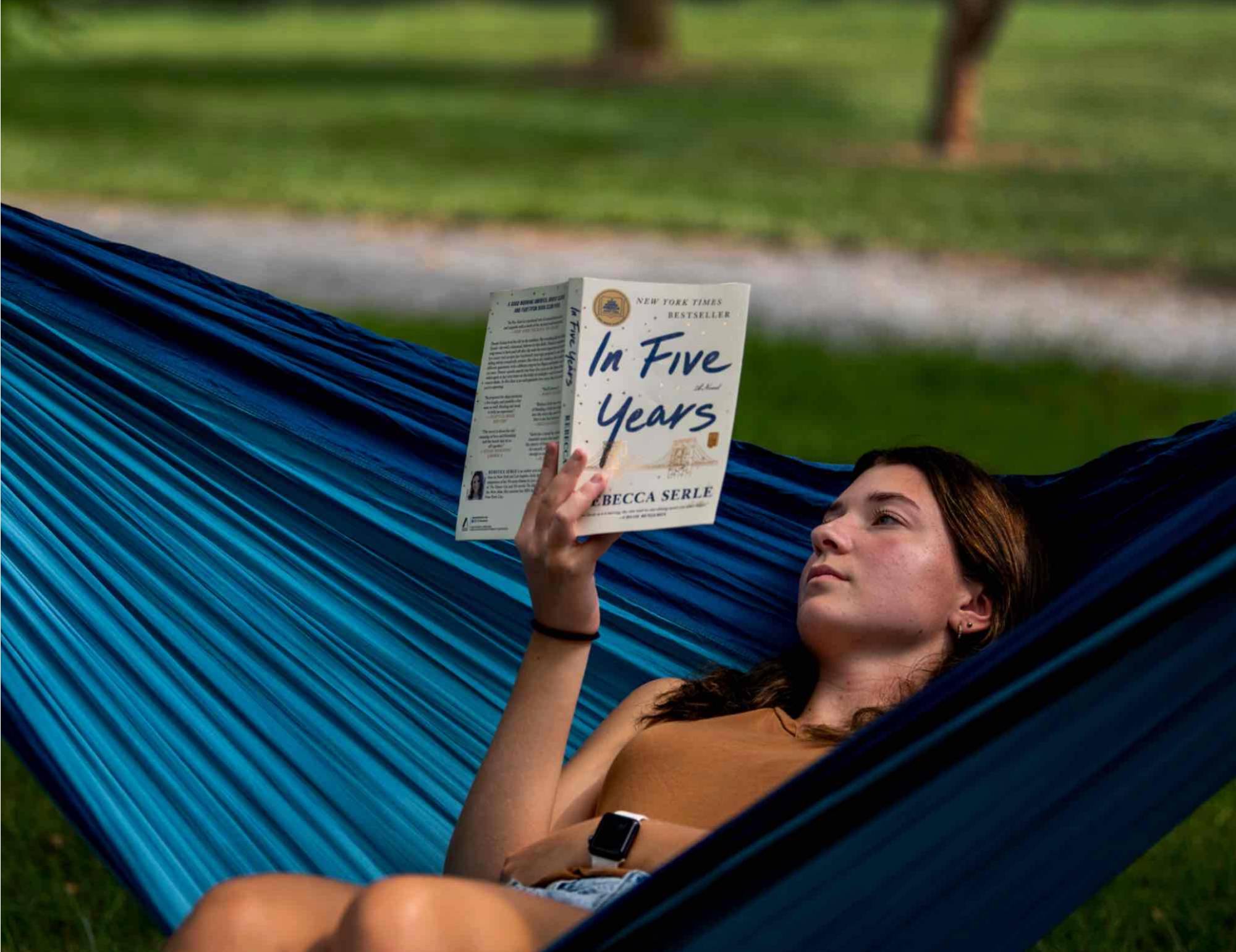 A person reading in a hammock
